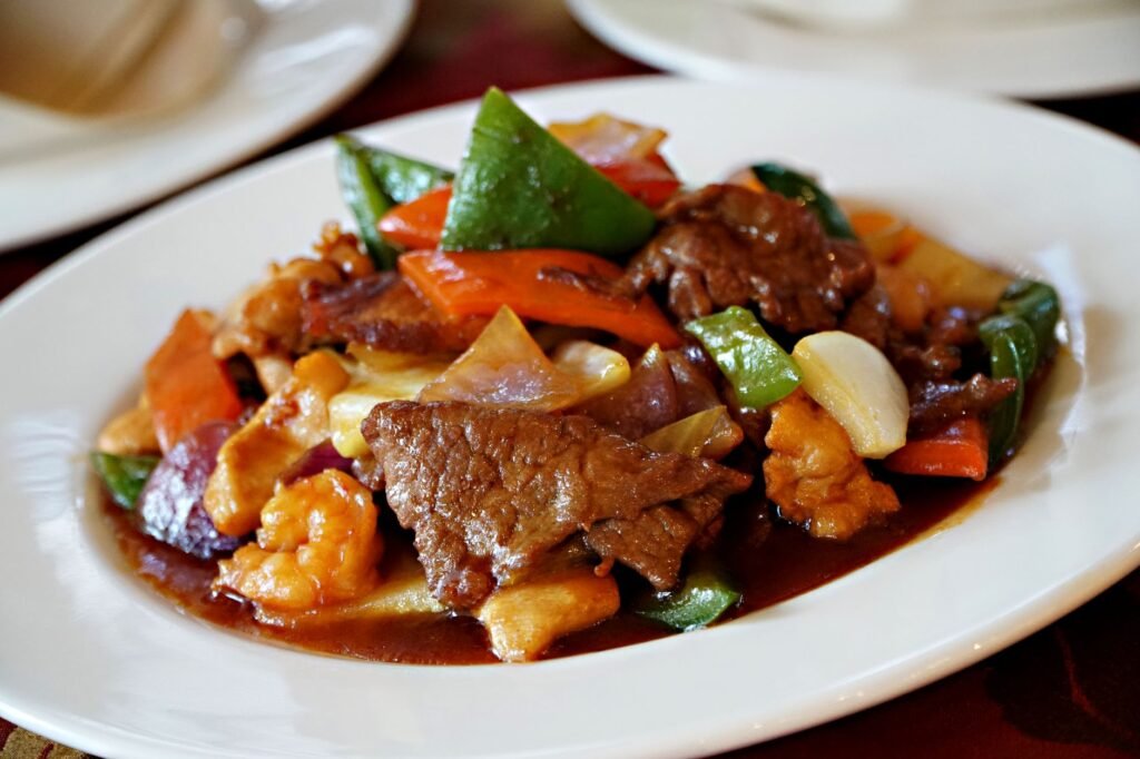 savory beef stir fry with vegetables on white plate